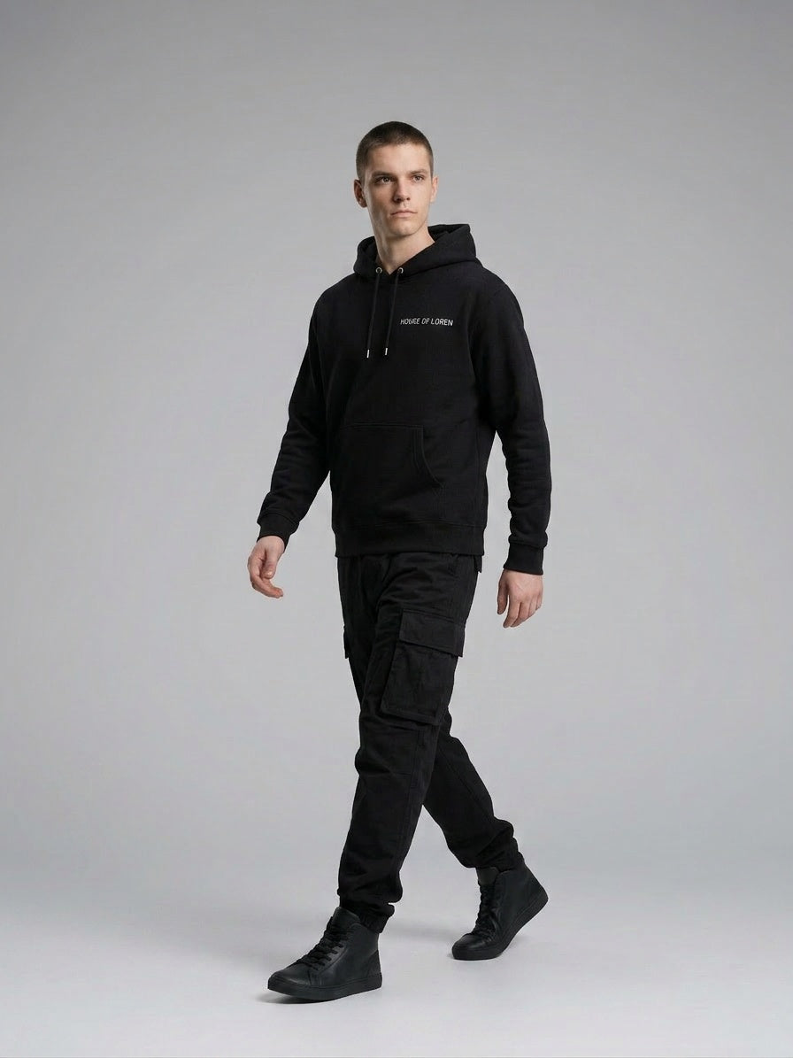 Model walking while wearing Signature Hoodie Unisex