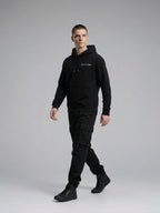 Model walking while wearing Signature Hoodie Unisex